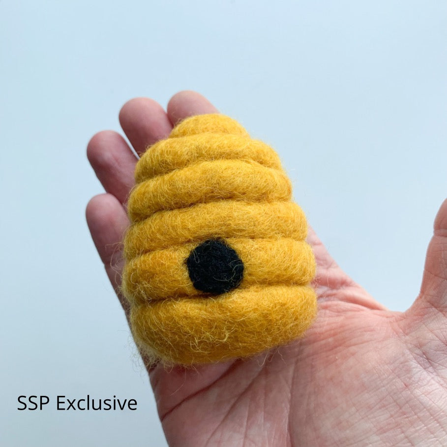 A needle felted beehive in a golden yellow that matches the felt bees, perfect for bee themed birthdays or play or even adding to crafting and fairy gardens 